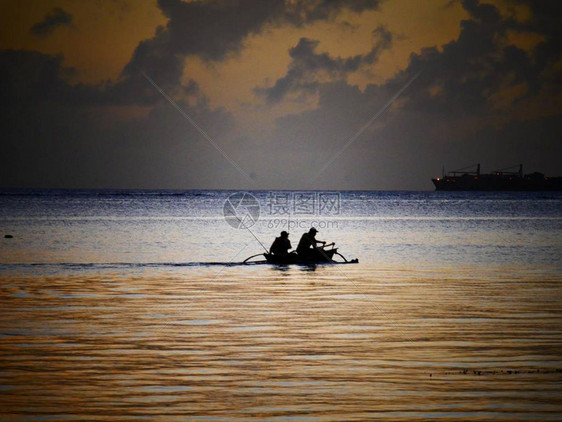 日落时在海上捕鱼的小帆船上两图片