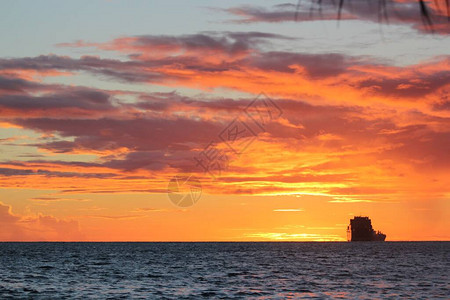 美丽的日落火热的天空和远处的一艘船图片