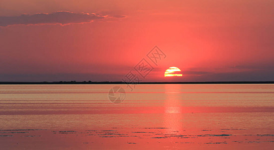 与美丽的红色日落在海waterf表面的风景图片