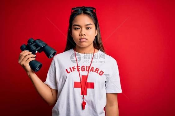 年轻亚洲女生命护卫身穿红色十字的T恤T用口哨和双筒望远镜图片
