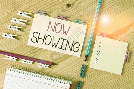 NowShowingshowing的写作注释商业概念让公众有机会看到目前可用的有色衣物纸空白提醒木地板背景办公室Groanded图片