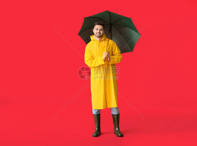 穿着雨衣和彩色背景雨伞的年轻人图片