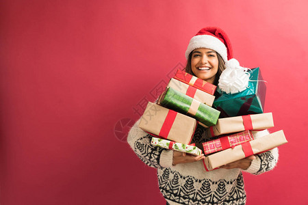 快乐的有魅力的女人带着一堆圣诞礼物在平淡图片