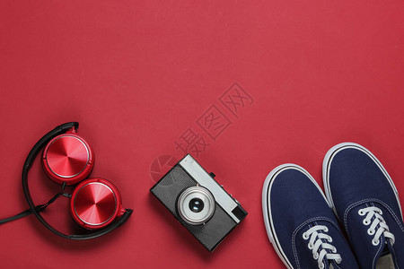 时装式耳机旧学校运动鞋红色背景的电影摄像头图片