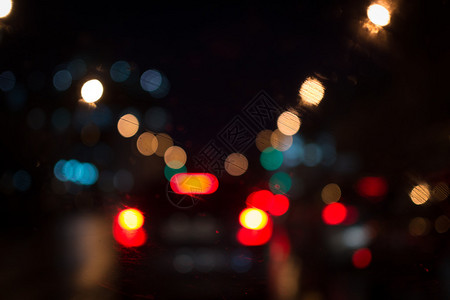 市中心的汽车灯亮晚上在挡风玻璃上背景图片