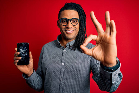 年轻非洲裔美国人男子手持破碎智能手机图片