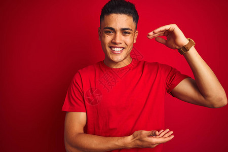 年轻的巴西男子身穿T恤站在孤立的红色背景上图片