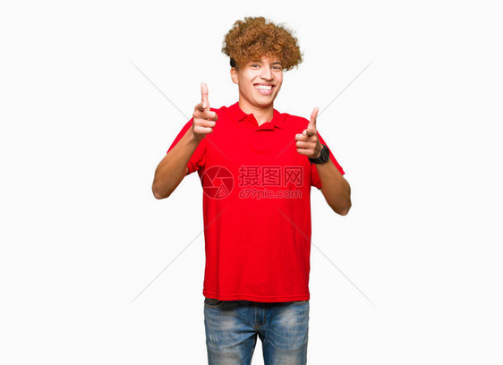 穿着红色T恤的英俊男长发帅气的年轻人用快乐和有趣的面孔将手指对着镜头图片