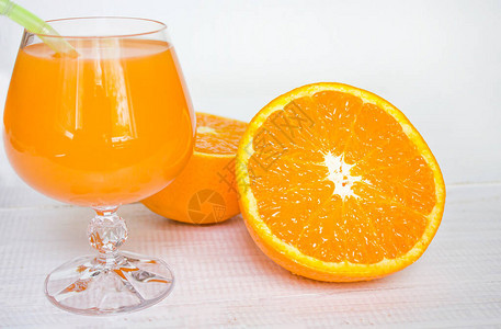 玻璃果汁橙汁和白木底的橙子维他命图片