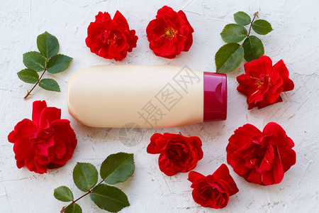 白色背景的洗发水瓶装玫瑰花女化妆品和配图片