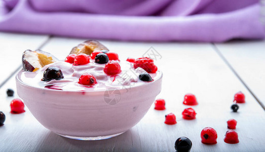 白桌上有水果梅子浆果的酸奶图片