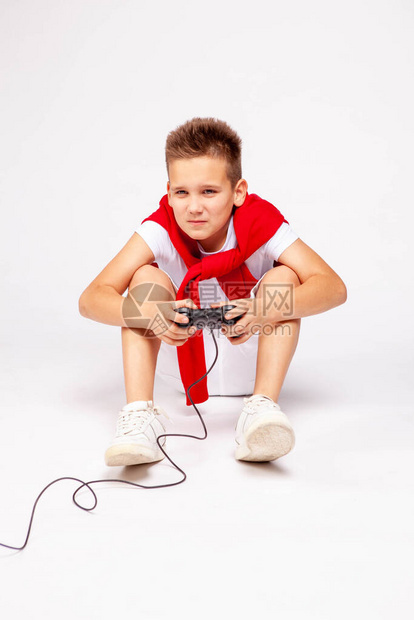这个男孩用操纵杆玩电子游戏图片