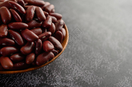 红豆在黑水泥地板上的木碗里图片