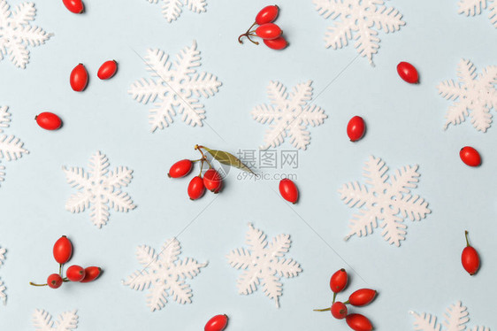 圣诞图案由浅蓝色背景上的雪花和红色浆果制成圣诞节寒图片