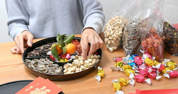 女人在农历新年装满盒子的零食图片