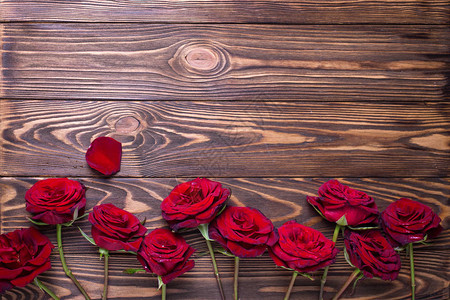 从带纹理的木制背景上的红色新鲜玫瑰花边框花卉静物文本的地方图片