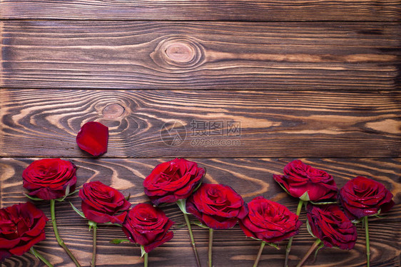 从带纹理的木制背景上的红色新鲜玫瑰花边框花卉静物文本的地方图片