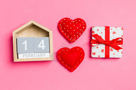 木制日历白色礼品盒和红色纺织心的顶端视图图片