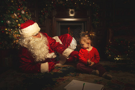 真正的圣诞老人在圣诞树附近和孩子们玩耍图片