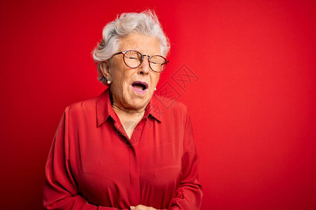 身穿休闲衬衫和红色背景眼镜手放在肚子上的白发美女图片