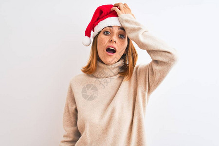 美丽的红发女人在孤立的下戴着圣诞帽图片