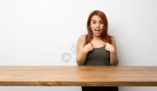 年轻的红发女青年在桌上的桌子图片