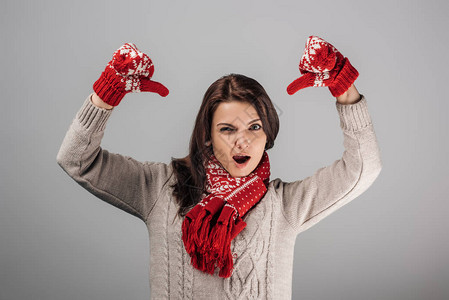 穿着红色手套和围巾的不高兴妇女在灰色图片