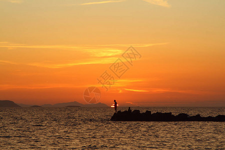 在夕阳下垂钓图尔古特雷斯海滨小镇和壮观的日落图片