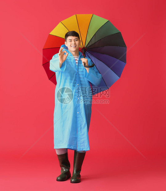 身穿雨衣伞在彩色背景上看得见的图片