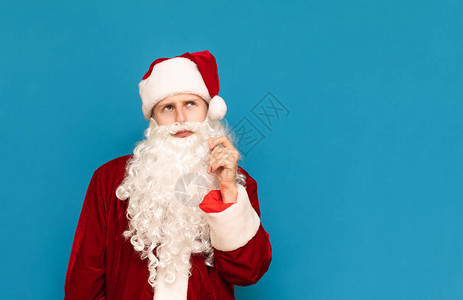 蓝色背景上沉思圣诞老人的特写肖像图片