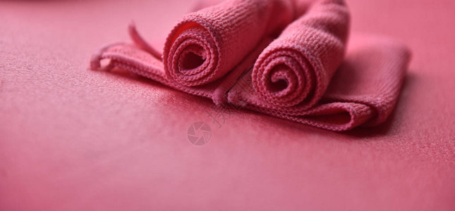 粉红色背景上折叠的粉红色毛巾图片