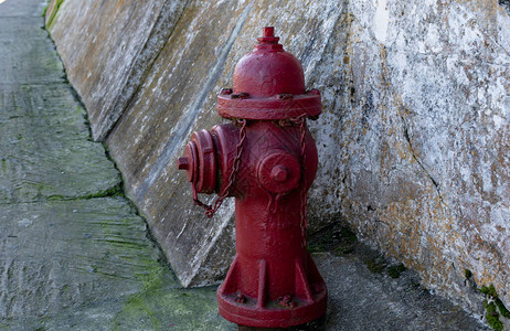 旧砖墙背景街道上的旧红消防栓在一条老街上发现图片