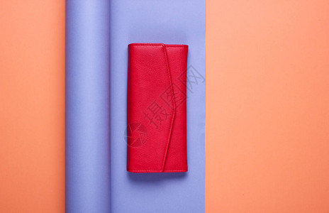 包裹纸面背景上的红色皮革钱包图片
