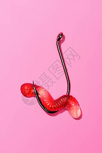 粉红色钓鱼钩上的红色粘蠕虫图片