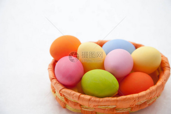 在雪地里放着许多彩色复活节彩蛋的篮子图片