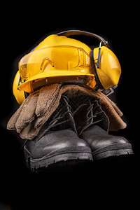 头盔手套和勺子放在黑暗的工作台上建筑工人的安全和卫生配图片