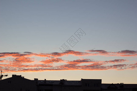 在夏季粉红橙色日落天空云层平行的背景下建造一栋图片