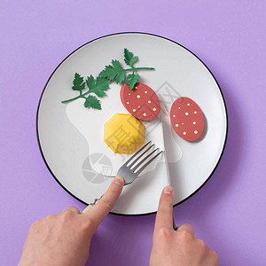 用叉子和刀子的手切纸煎鸡蛋和香肠逼真的手工纸制品纸艺和工艺极简艺术食品概背景图片