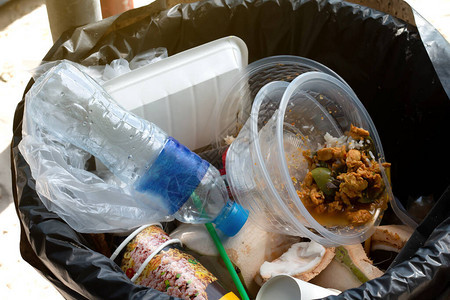垃圾箱上的塑料瓶和食物垃圾图片
