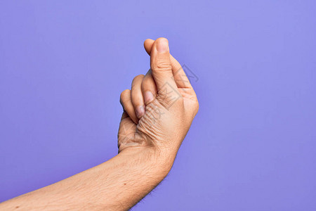 Caucasiansian年轻男子的手在孤立的紫色背景上举起手指图片