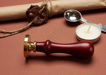 封信袋蜡烛和棕色纸卷棕色背景的木制手柄图片