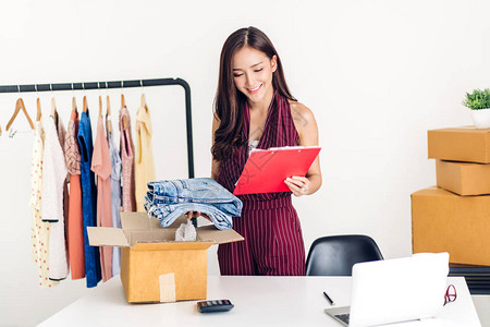 年轻的亚洲女自由职业者从事中小企业在线购物和在家用纸板箱包装衣服图片