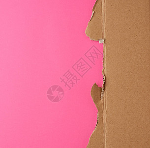 粉红色背景的褐色纸片被撕裂的边缘图片