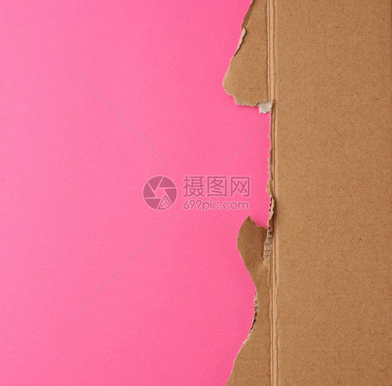 粉红色背景的褐色纸片被撕裂的边缘图片