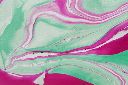 用于墙纸或印刷品的全帧视图中绿色和粉红色或洋红色流体漩涡波的抽象大理石化图片