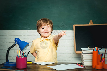 从小学的男孩学生在校园里快乐微笑的小男孩学生对黑板很开心教育和阅读的图片