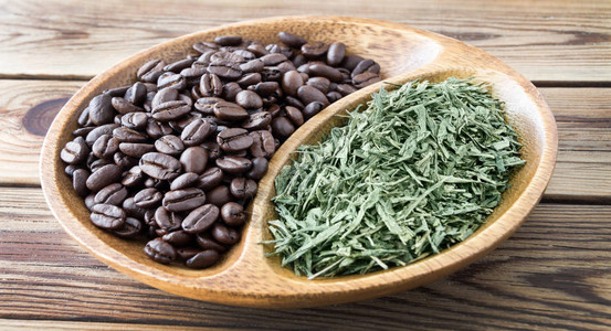 咖啡豆和绿茶在一个木碗图片