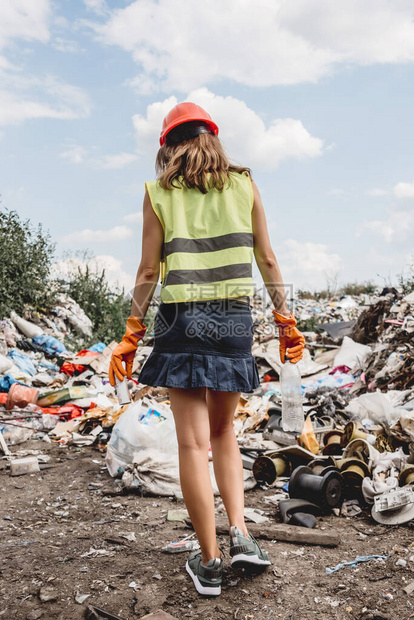 帮助清洁塑料垃圾填埋场的女志愿人员图片