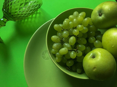 三个苹果和一堆葡萄在绿色的图片