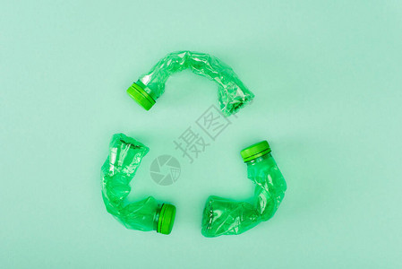 从绿色背景生态概念的皱巴塑料瓶中回收标图片